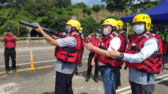 縣府秘書長陳斌山、議長鍾東錦等人在岸上視察演練過程，並且換上救生衣體驗拋繩槍發射。（李京昇攝）