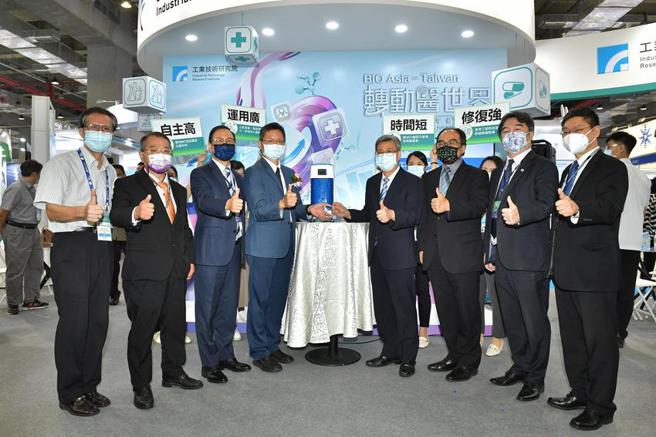 （工研院生医与医材研究所所长林启万（左四）在生技展上，向前副总统陈建仁（右四）、亚洲生技大会主席李锺熙（左三）、经济部工业局局长吕正华（右三），说明工研院研发的「细胞组织层片生医材料整合系统」，仅需30分钟，即可打造出一块如「果冻般」的细胞组织层片，并将可直接临床使用。图／工研院提供）