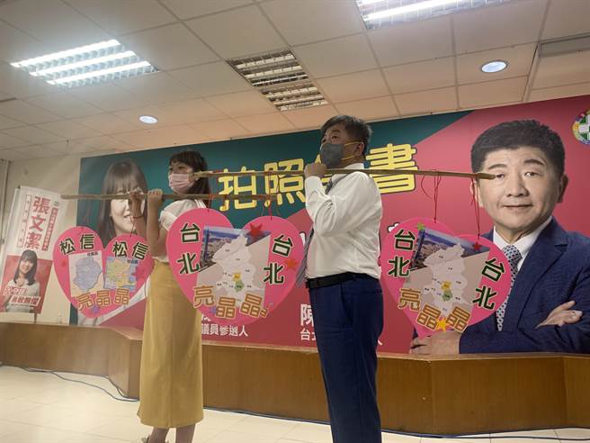 张文洁（左）送陈时中（右）扁担，要他扛起台北市长，自己则扛起爸爸的重担。（黄婉婷摄）