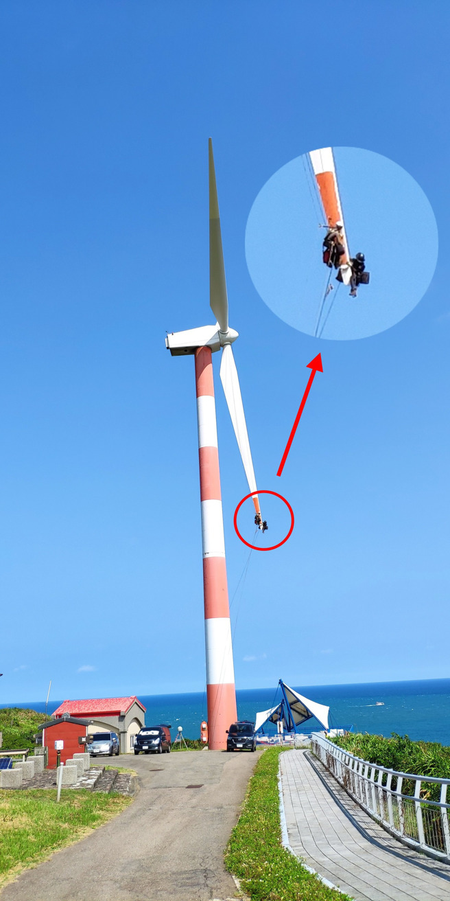 1名網友在1處風力發電機的葉片上發現有2名人員疑似在做清潔、維修，2人身上雖有多條安全繩，但烈日下在如此高空作業仍讓人捏冷汗。（翻攝自臉書「爆廢公社」）