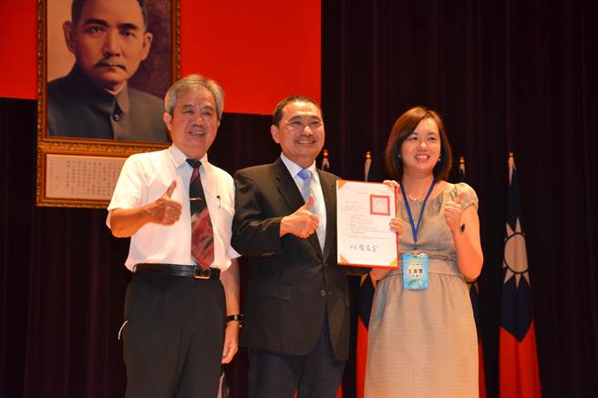 新任淡水国中校长王洁雯也与曾任多届校长的父亲王仁宏一同上台，接受新北市长侯友宜表扬，校长父女檔传承交接的画面相当罕见。（蔡雯如摄）