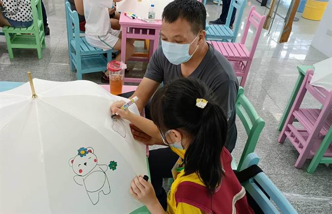 大园警分局也安排孩童与家长一起体验手工彩绘阳伞、降雨廊道等趣味活动。（翻摄画面／蔡明亘桃园传真）