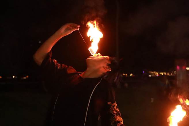 火舞表演者德龙就学期间利用周末从事火舞表演，不但成功考取街头艺人证照，也让更多人了解到火舞的美丽。即便训练途中烧破好几件演出服，头髮、肌肤受的伤也不在少数，但火舞已经成为他生活的一部分。图为德龙现场吞火，观眾惊呼连连。（实习摄影记者谢家瑀摄）