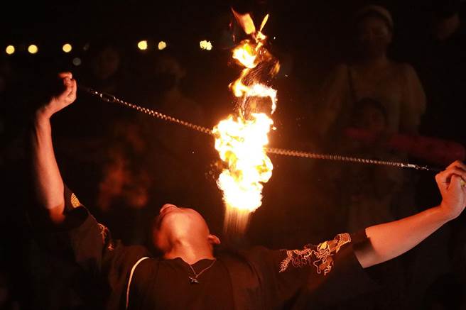 火舞表演者德龙就学期间利用周末从事火舞表演，不但成功考取街头艺人证照，也让更多人了解到火舞的美丽。即便训练途中烧破好几件演出服，头髮、肌肤受的伤也不在少数，但火舞已经成为他生活的一部分。图为德龙在头上转动多个火球，现场观眾惊呼连连。（实习摄影记者谢家瑀摄）