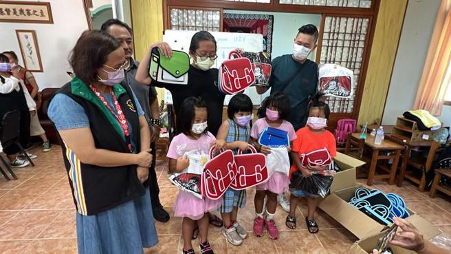 怪奇研究社和JumpFromPaper创办人林飞比（后排右2）、BRAND T.INC（潮依国际贸易有限公司）创办人丁崑民（后排右1）29日到台东县延平乡红叶部落，赠送部落课辅班「红叶爱的小屋」孩童品牌包包与潮T。（图/ 中央社）