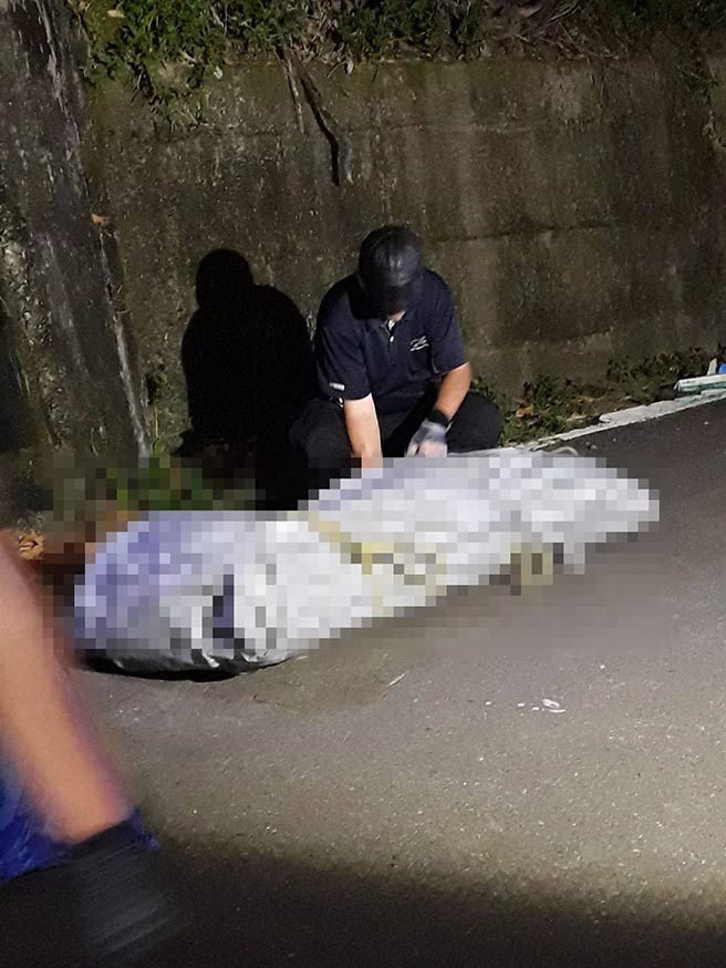 林姓凶嫌在太平山区被找到，警方昨深夜将尸体抬上路边。（警方提供）