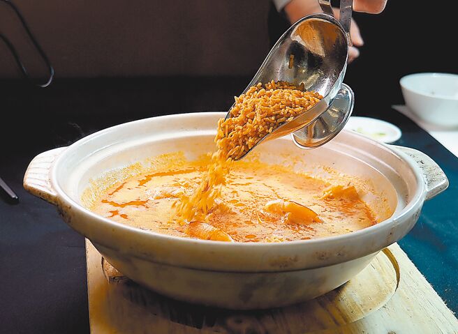 在〈珍寶南洋小廚〉品嘗〈貴妃泡飯〉，專人桌邊服務將酥炸香米凌空沖入湯中，非常有儀式感。圖／姚舜