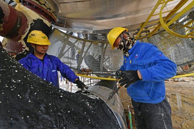 大陆7月分制造业PMI为49.0％，比上月下降1.2个百分点。图为大陆福建泉州工人在修造大型户外石化设备。（中新社）