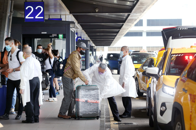 疫情趋缓，出国旅游的民眾越来越多，图为桃园机场第一航厦外，刚入境的旅客正在排队搭乘防疫计程车。（范扬光摄）