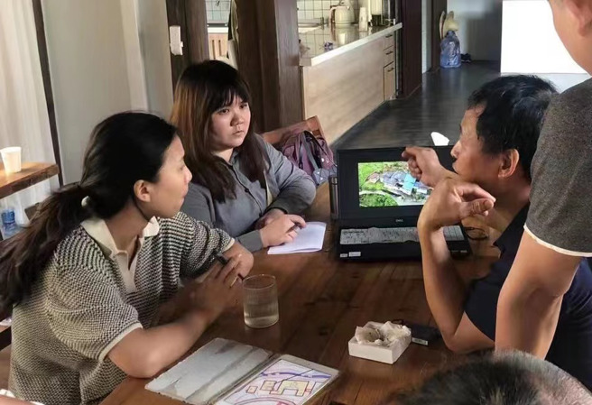 村民向张瑜心（左2）咨询老屋改造。（彭莉芳 摄）
