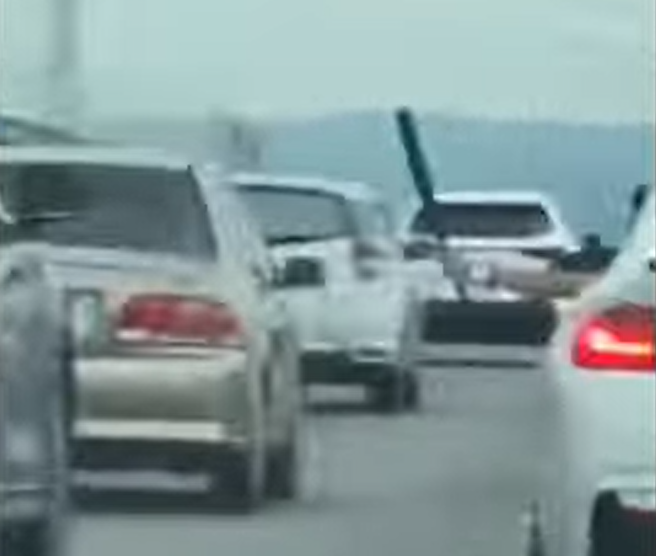 国1中港交流道1名BMW驾驶先在台湾大道与1名休旅车驾驶发生纠纷，2车开上国道后，BMW驾驶竟摇下车窗「伸出球棒挥舞」并沿路逼车叫嚣。（翻摄自脸书「记者爆料网」）