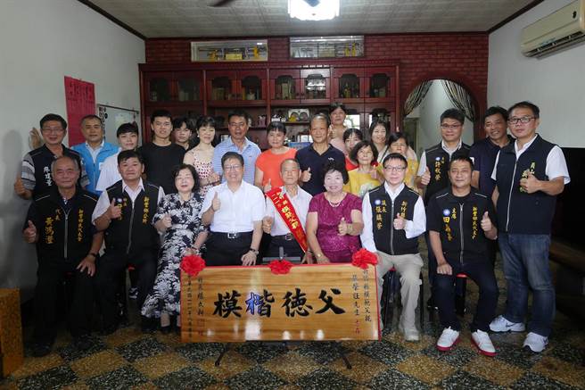 新丰乡84岁张荣旺（中）获选新竹县模范父亲，县长杨文科（中左）致赠木匾、琉璃奖座等礼品祝贺。（新竹县政府提供／罗浚滨新竹传真）