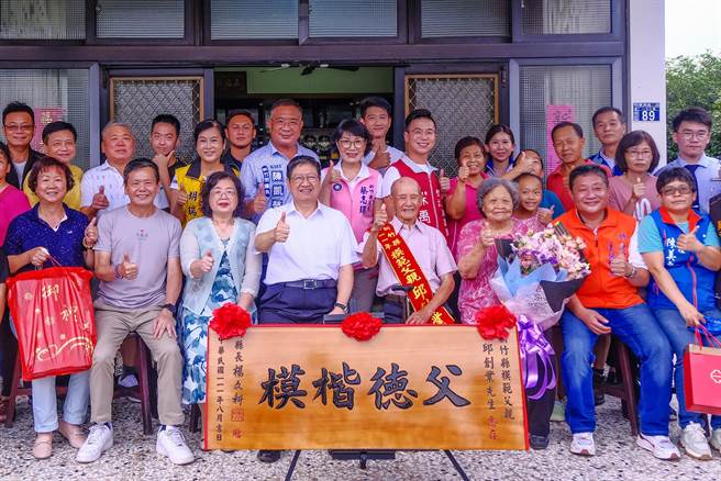 县长杨文科（中）到竹北市模范父亲邱创业（中右）家中道贺，参选竹北市长的立委林为洲（左二）等争取连任的民代「搭便车」争取曝光。（罗浚滨摄）