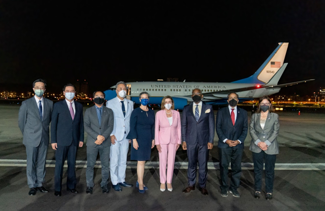 裴洛西專機2日晚間降落松山機場，她身穿粉紅色套裝現身。外交部提供