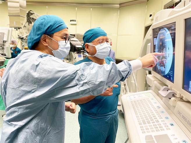 吴弘斌主任（左）与许权振副院长（右）一同检视电子耳电极植入后检查影像。（台中慈济医院提供）