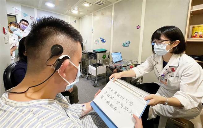 听力师协助周健勛新植入电子耳开频。（台中慈济医院提供）