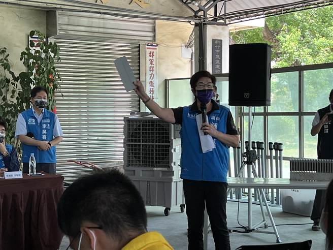 市议员锺淑英拿出铝镁锌板，质疑部分建物屋顶为何要改用指定厂商的特殊建材。（王惠慧摄）