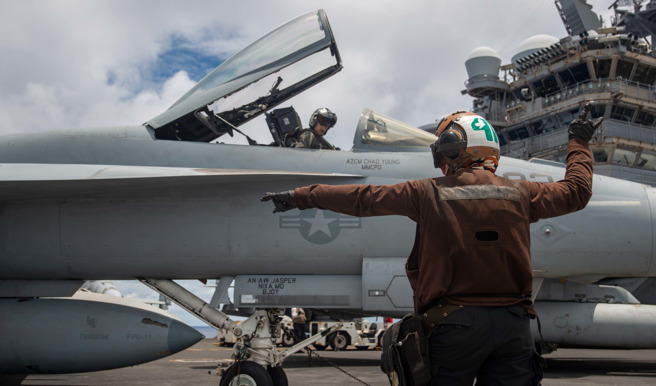 F-18超级大黄蜂正在航舰甲板进行起飞前准备。(翻摄自第七舰队脸书)