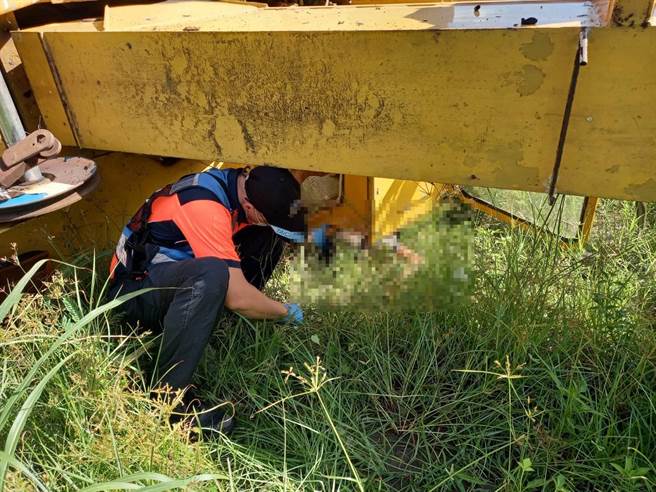 救护人员趋近吊车下方查看，驾驶已无命迹象。（台南市消防局提供／程炳璋台南传真）