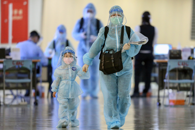 农历春节将至，许多台商与旅外国人会赶在除夕前回台，受到新冠疫情影响，返国旅客都要入境检疫14日（7＋7）再加上7日的自主管理，为了在除夕日前够完成居检出关与亲友团聚，许多人都算好时间，提早最少三星期检疫大限前返国，桃园机场这周的入境旅客也明显增加，入境旅客全家一身防护装备，防护衣、面罩、口罩无不齐全，包的密不透风，原本与父母愉快而兴奋的飞行，却成为孩子们的一场噩梦。」（非新闻当事人）（陈麒全摄）