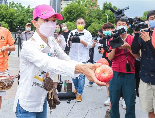 狄莺发放苹果给媒体，祝福大家平安。（粘耿豪摄）