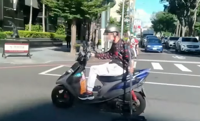 有网友在路上目击1名男骑士竟边骑车边「拖着点滴架」，点滴架的轮子就跟着在地上转，该网友录下影片称「到底要命还是不要命啊？」（翻摄自脸书「爆废公社」）