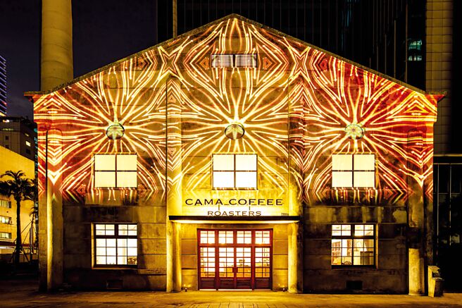 台北松菸文创园区里昔日的古蹟锅炉房如今已变身为〈CAMA COFFEE ROASTERS 豆留文青〉，入夜后透过光雕华丽变身。图／Cama cafe