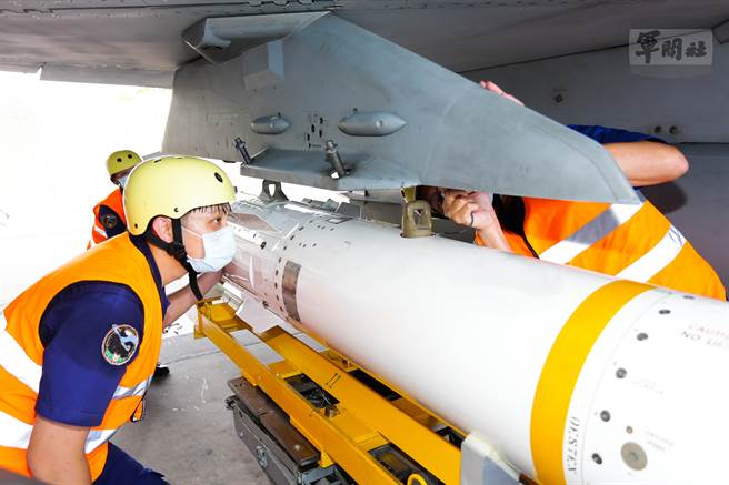 官兵依标准作业程序，将鱼叉飞弹装挂置战机上。（军闻社提供）