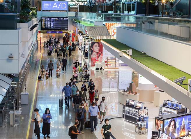 中央流行疫情指挥中心宣布自8月8日零时起，桃园机场开放转机旅客候机期间至出境区购物及用餐，同时取消专属候机室、转机停留时间12小时内，及行程须开立在同一本票等规定，大幅提升转机作业效率及旅客便利性，有助航空业者争取桃园机场中转旅客商机。图为地勤人员引导转机旅客到专属候机室。（陈麒全摄）