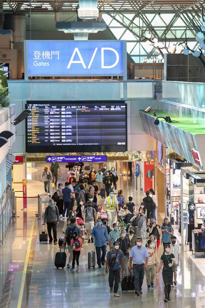 中央流行疫情指挥中心宣布自8月8日零时起，桃园机场开放转机旅客候机期间至出境区购物及用餐，同时取消专属候机室、转机停留时间12小时内，及行程须开立在同一本票等规定，大幅提升转机作业效率及旅客便利性，有助航空业者争取桃园机场中转旅客商机。图为地勤人员引导转机旅客到专属候机室。（陈麒全摄）