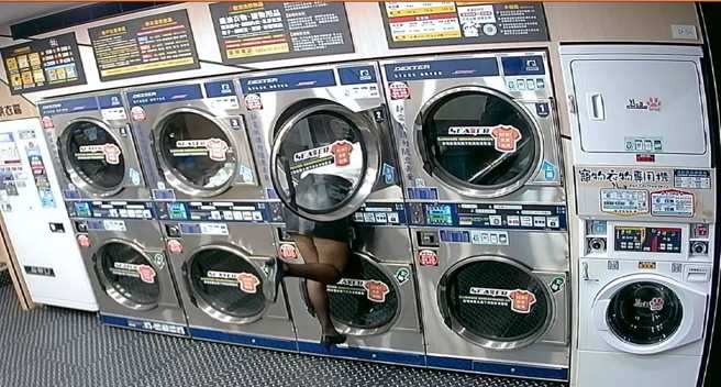 穿着OL全身套装、黑丝袜的女模特儿站在自助洗衣店内让人拍摄，该女模甚至「钻进」洗衣机内，剩长腿在机器外，监视器影像曝光让店家气炸。（翻摄自脸书「我是万华人」）