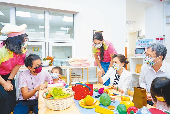 經濟部長王美花、台電總經理王耀庭與幼兒一起玩扮家家酒。（台電提供）