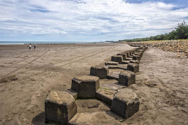 新月沙灣北段海岸防護改善工程第1期，回填砂石補大凹洞，設置1公里長的護岸到山腳碼頭，避免沙灘被侵蝕淘空。（羅浚濱攝）
