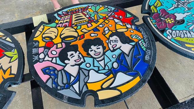 台北市政府水利工程處「台北蓋水」第2期彩繪人孔設計成果展將於11日至15日在北市府一樓中庭登場，24款特色彩繪人孔蓋一次看過癮。圖為中山區的「快樂中山」人孔蓋。
（圖/ 中央社）
