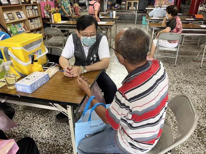 台南市衛生局今天啟動COVID-19疫苗接種巡迴服務，首站到左鎮區北極殿，衛生局長許以霖（左）親自擔任問診醫師。（台南市衛生局提供／曹婷婷台南傳真）