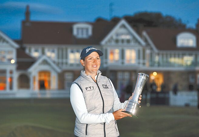 布海拿着英国公开赛冠军奖杯庆祝，天色明显已经昏暗。（美联社）