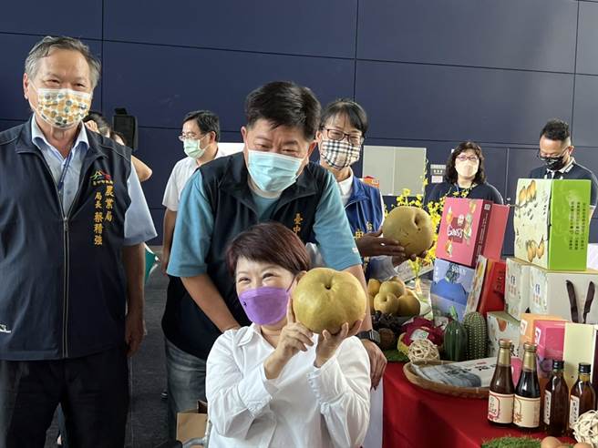 台中市长卢秀燕拿起比脸还大的梨子，强调台中水果、甜品品质都好。(林欣仪摄)