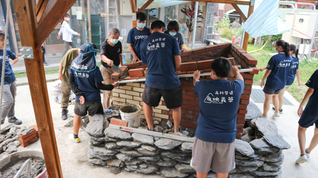 高雄市立中正高工建筑科师生团队一同进入原乡实作，期许能实践「赋权社区」的理念，与在地基层学校共同打造永续性的公民学堂。图为师生共同完成窑作。(照片/高雄科技大学提供)