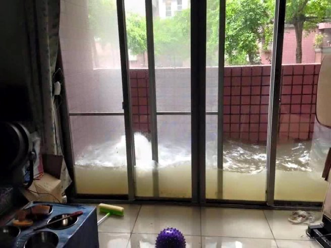 網友分享住家陽台的淹水畫面，只見濁水被氣密窗完全阻隔，形成像魚缸般的特殊情景。（圖／取自爆廢公社）
