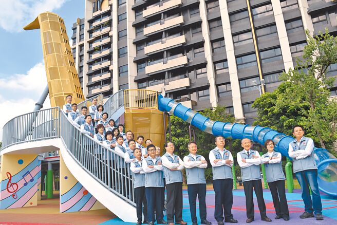 新完工的头份音乐公园以1座大型萨克斯风为造型主题的溜滑梯，当公园主景观，苗栗县长徐耀昌10日带领县府团队到场合影。（谢明俊摄）