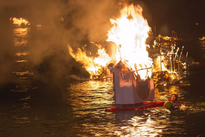 基隆中元祭各宗族精心制作的水灯11日傍晚在市区遶境游行，午夜11点在望海巷海域施放水灯，今年主普黄姓宗亲水灯点燃后由救难协会人员拖往海上。（黄子明摄)
