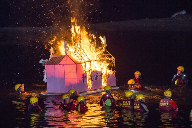基隆中元祭各宗族精心制作的水灯11日傍晚在市区遶境游行，午夜11点在望海巷海域施放水灯，今年主普黄姓宗亲水灯点燃后由救难协会人员拖往海上。（黄子明摄)