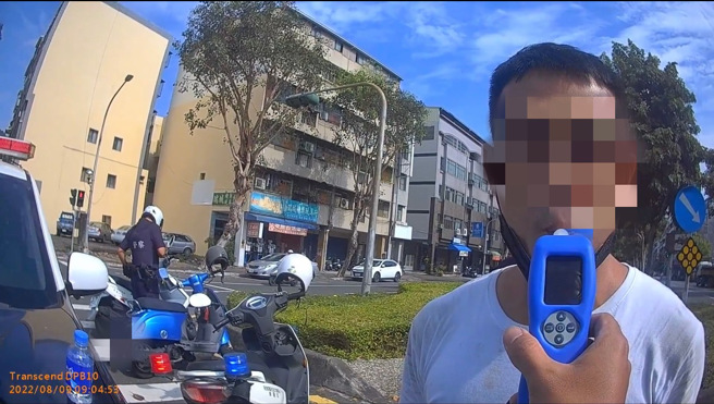 高雄一名男子骑机车违规左转遭后方员警拦停，一身酒气却辩称吃槟榔，酒测出炉脸都绿了。(叶庭欣翻摄)