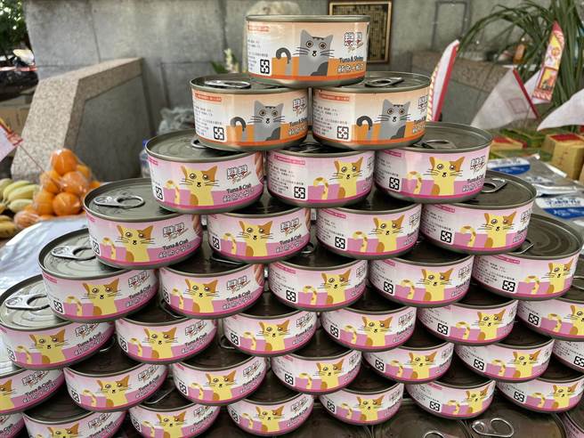 嘉义县家畜疾病防治所今举办一场别开生面的「兽魂碑」中元感恩祈福祭典，供桌上摆满牧草、犬猫罐头、动物饲料等各式动物食品。（吕妍庭摄）