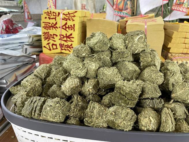 嘉义县家畜疾病防治所今举办一场别开生面的「兽魂碑」中元感恩祈福祭典，供桌上摆满牧草、犬猫罐头、动物饲料等各式动物食品。（吕妍庭摄）