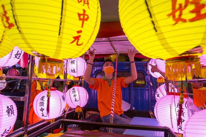 配合鸡笼中元祭 鸡笼中元祭工作人员在引领水灯游行的货车子上整理灯架。（黄子明摄) 