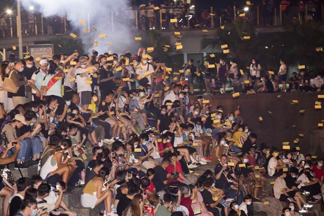 配合鸡笼中元祭 参观鸡笼中元祭水灯施放的民眾挤满望海巷海堤，各姓宗亲会完成祭拜仪式后，将经衣洒向海中，却直接飘落人群中。（黄子明摄) 