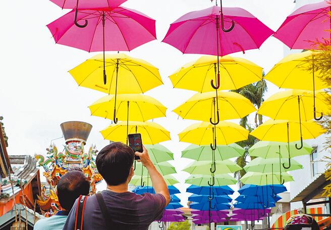 为迎合大士爷祭特殊「雨伞节」称号，今年大士爷庙旁特别以雨伞布置拍照打卡墙、天顏伞平安街等装置艺术，呈现在地人文特色。（吕妍庭摄）