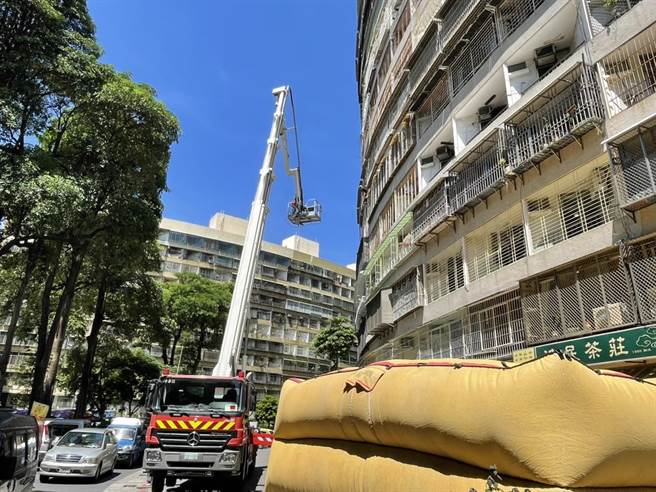 员警与消防队赶到现场，除了在地面铺设救生气垫，也透过云梯车安抚于男，现场消防人员架设救护器材戒备。(警方提供／林雅惠高雄传真)