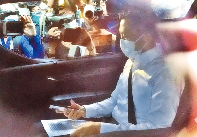 12日在總統官邸舉行的民進黨臨時選對會敲定「換堅」後，林智堅低調搭車離開時在車上看著手稿，媒體紛紛貼上車窗採訪。（姚志平攝）